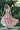 Girl in a pink dress , with maxi skirt and two piece and ruffle detailing standing outdoors with greenery in the background- tea princess